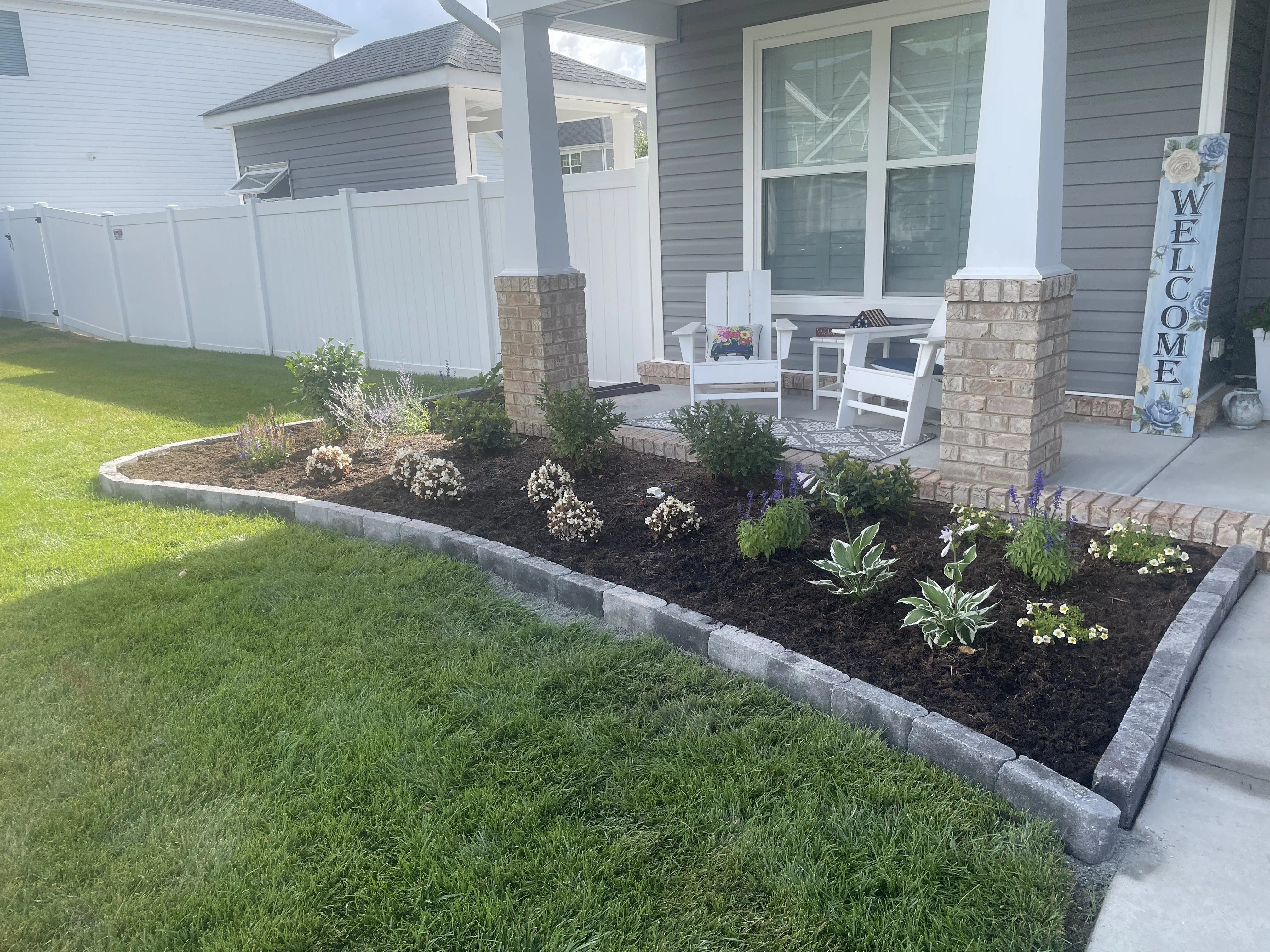 Front porch with flower bed and welcome sign