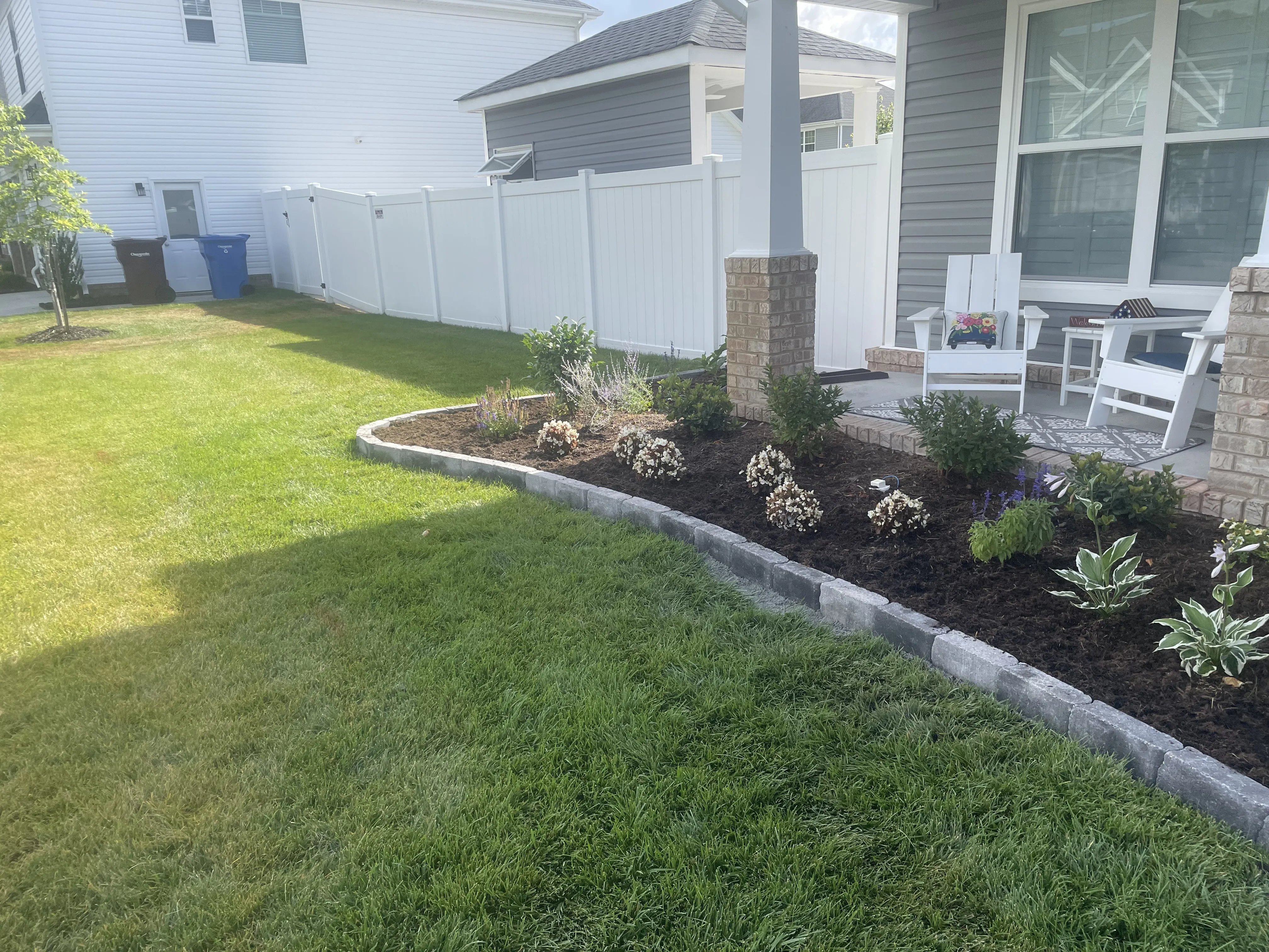 Front porch garden bed with small flowers and plants