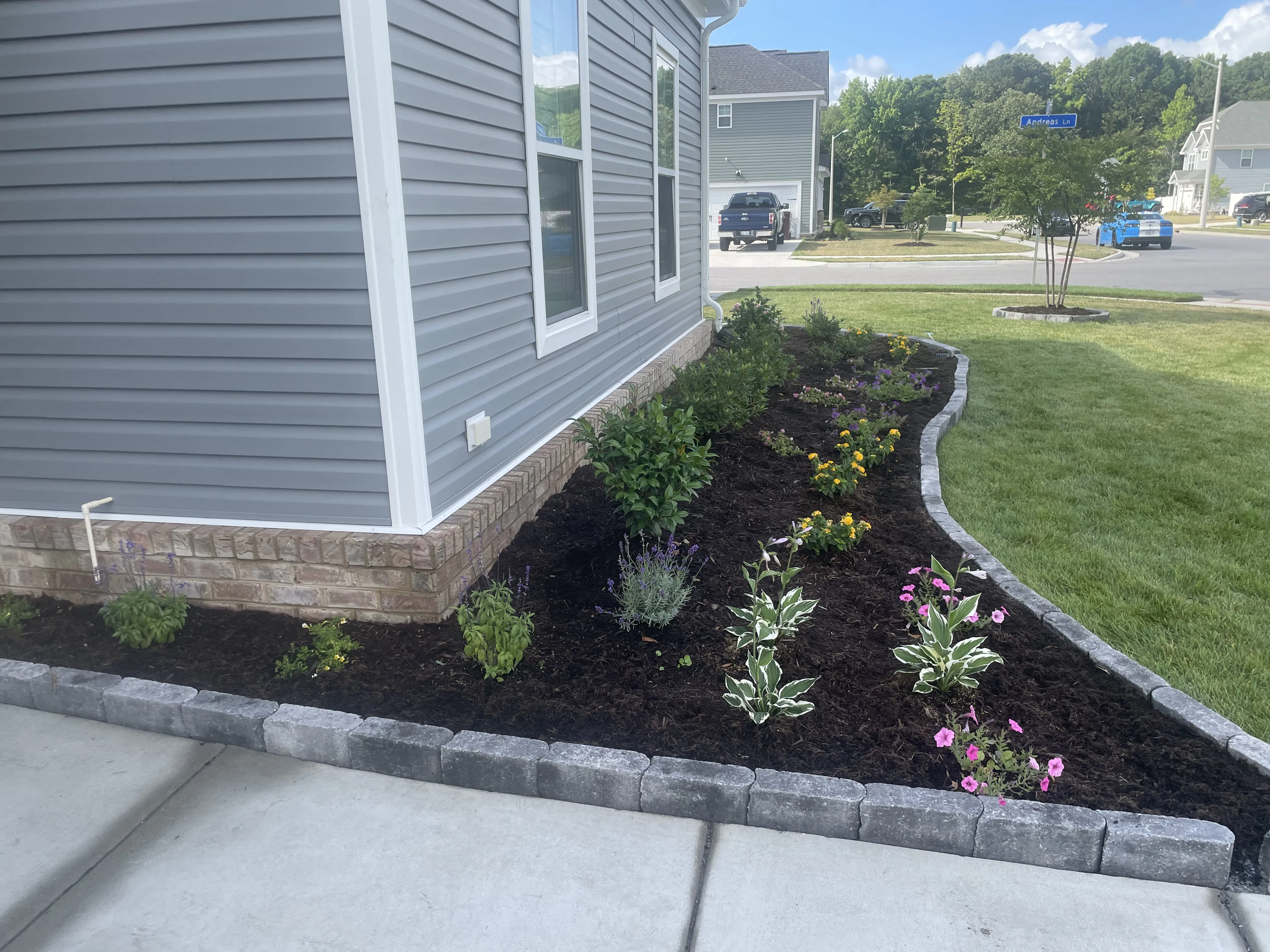 Curved landscaped flower bed along house